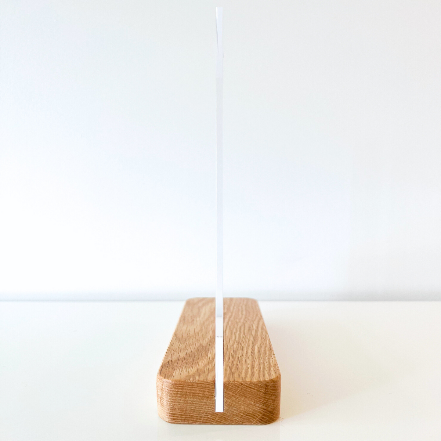 Side view of a clear acrylic to-do list with a sleek oak stand, showcasing its minimalist design and sturdy construction for home office organization. Perfect for daily task management.