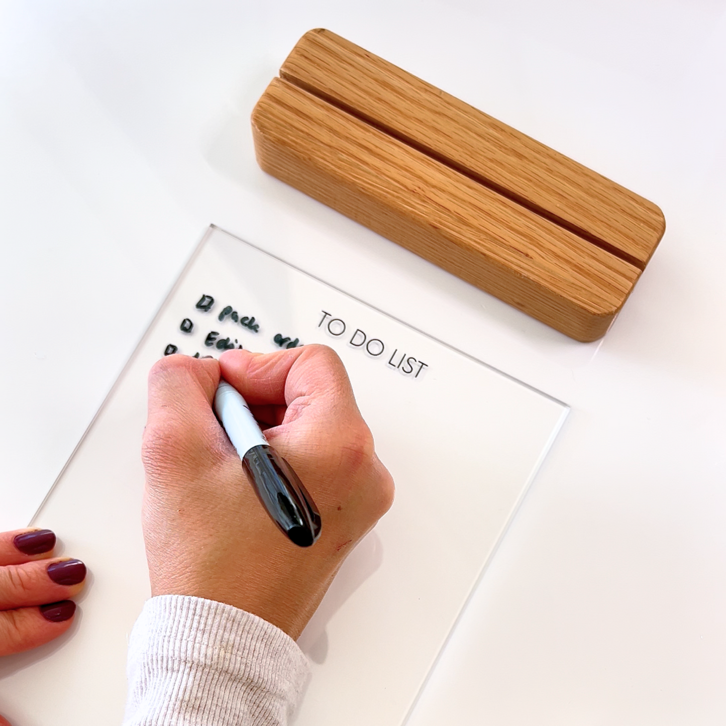 Hand writing on a acrylic to do list with a oak stand