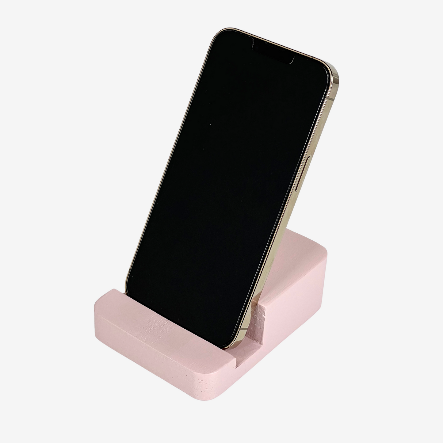 Lux Navia pink wooden phone stand holding a smartphone, with the image taken from the front, combining a minimalist aesthetic with practical functionality for any workspace or home.