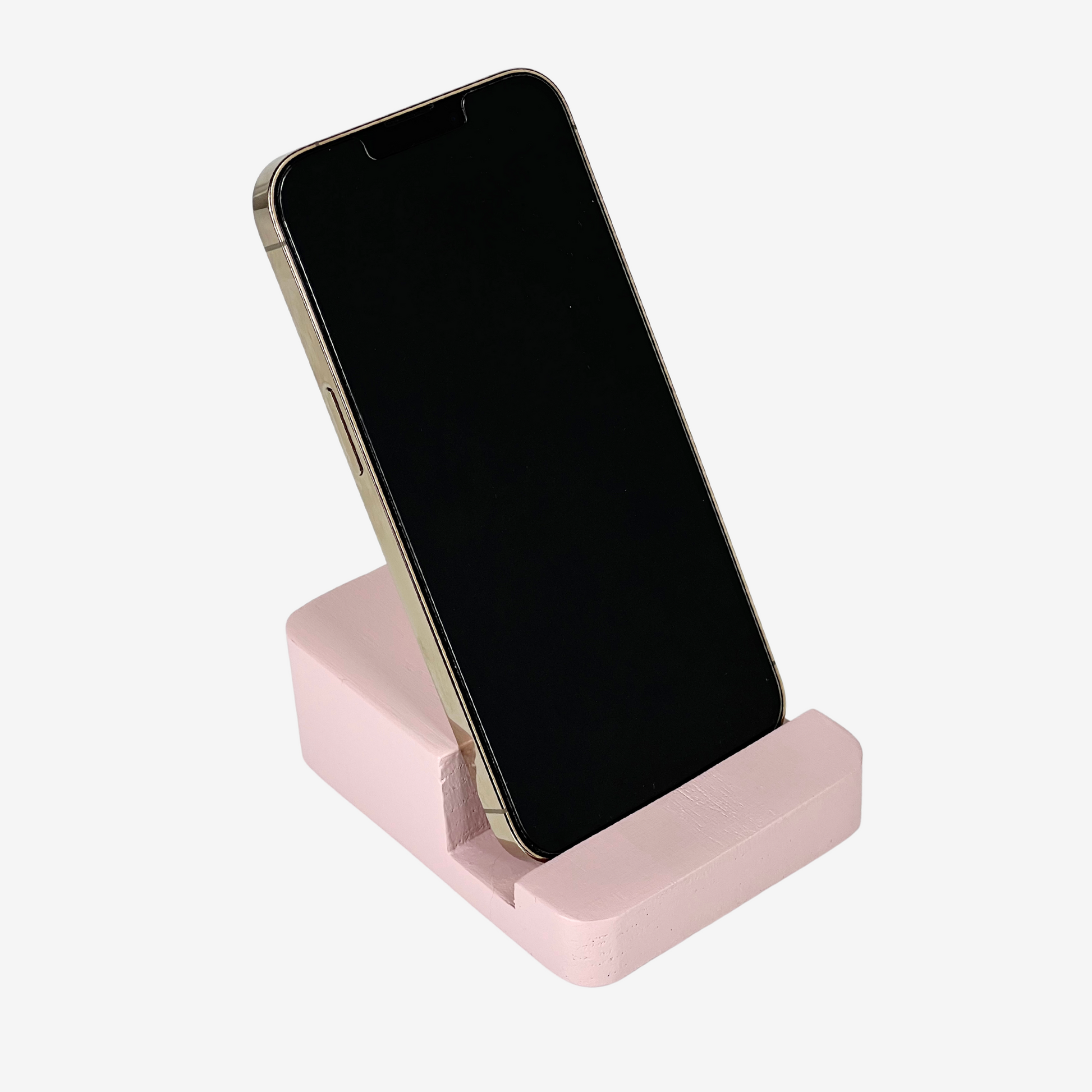 Lux Navia pink wooden phone stand holding a smartphone, with the image taken from the front, combining a minimalist aesthetic with practical functionality for any workspace or home.