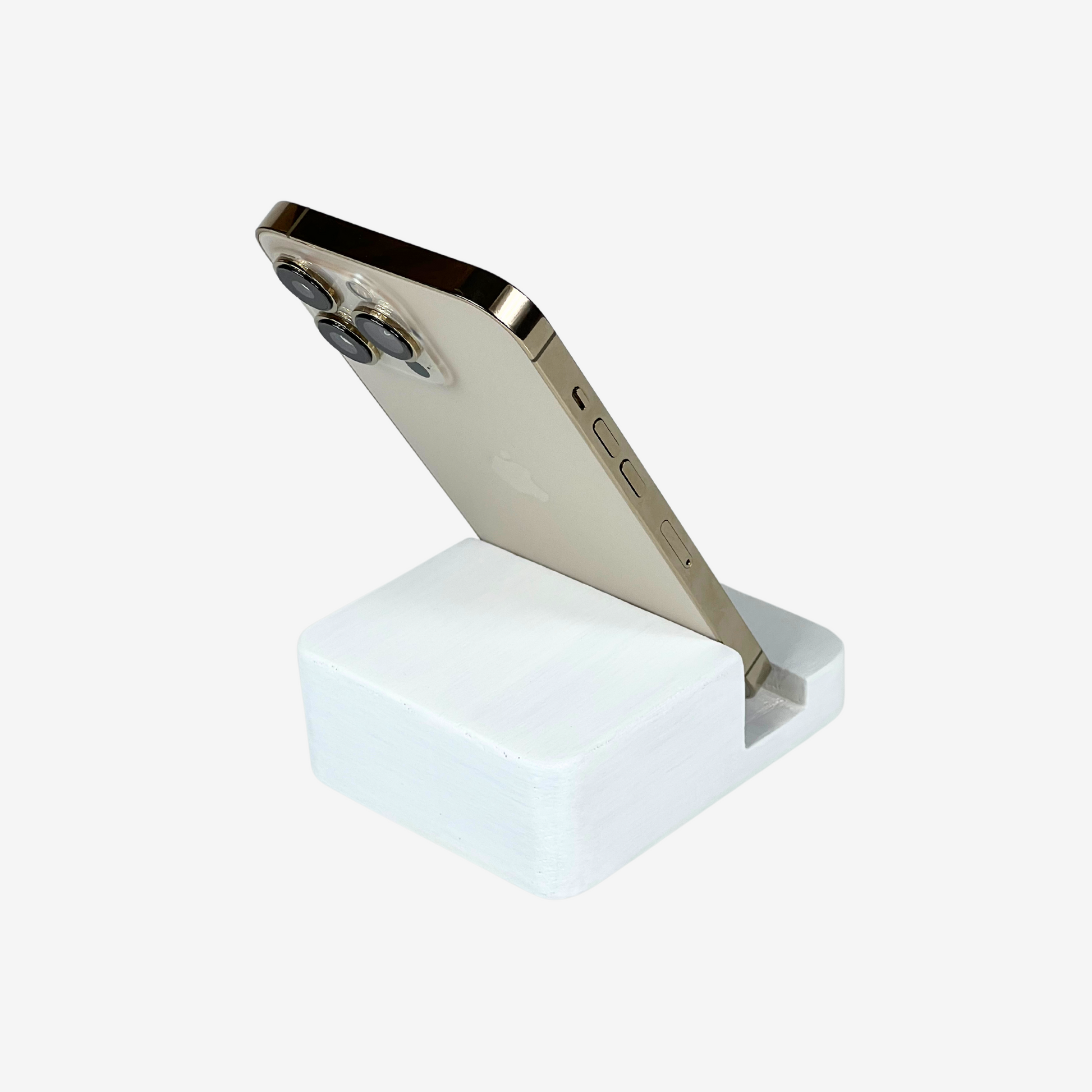 Lux Navia white wooden phone stand holding a smartphone, with the image taken from the back, combining a minimalist aesthetic with practical functionality for any workspace or home.