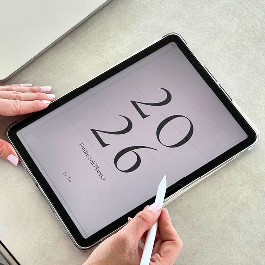 using an iPad pen on the iPad displaying 2026 future self planner on a light surface